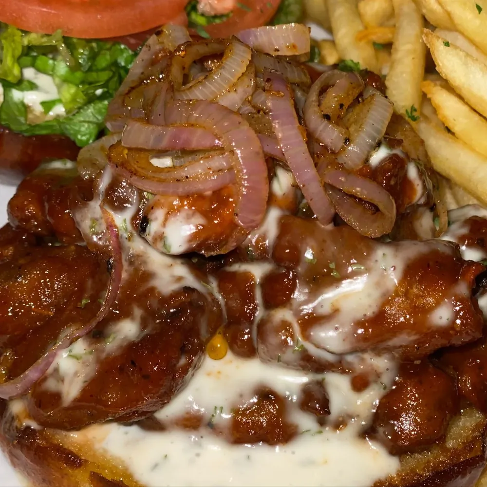 Fried oyster mushroom chk&rsquo;n in BBQ sauce with grilled onions and a ranch drizzle, served with fries